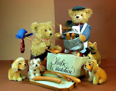 © Dr. Ursula Fellberg: Teddybär „Wurstmaxe“, ist aus der Serie „Alt-Berliner Originale“ (von Hermann Coburg) von Teddy’s, der Wanderer und die Hündchen sind vor Steiff; alle gehören zur Sammlung Fellberg