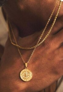 Ordinary Magic Foto eines goldenen Amuletts mit Kompassmotiv