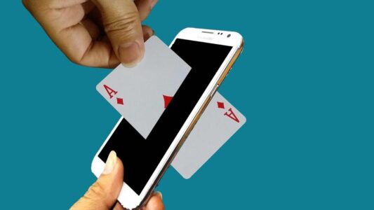 Ordinary Magic Zaubertrick eine Spielkarte wird durch ein Handy gesteckt