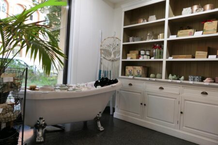 sauberkunst produkte im regal und eine badewanne