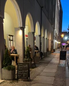 vinothek gäste sitzen abends draussen an tischen