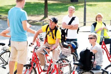 teilnehmer einer fahrradtourhören einem guide zu