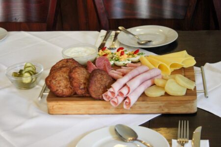 paddenwirt buletten shinken und käse auf einer holzplatte